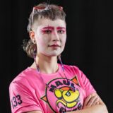 Crashy Go Lucky wearing pink eye makeup and staring at the camera