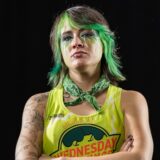 T-Wrecks looks seriously at the camera with green hair